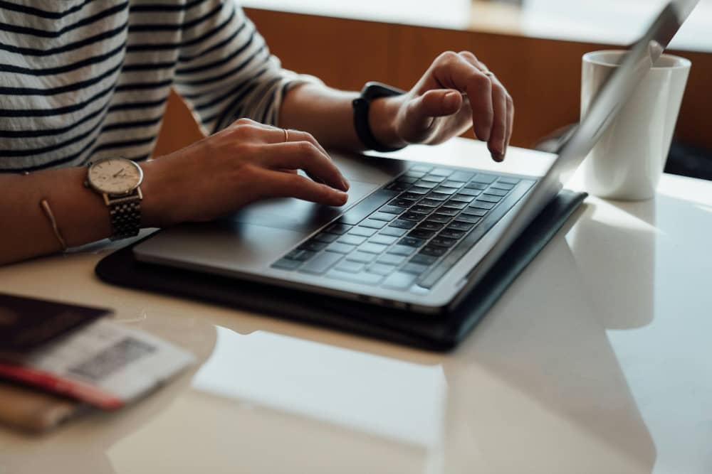 mains d'une femme demandant un rachat de crédit en ligne